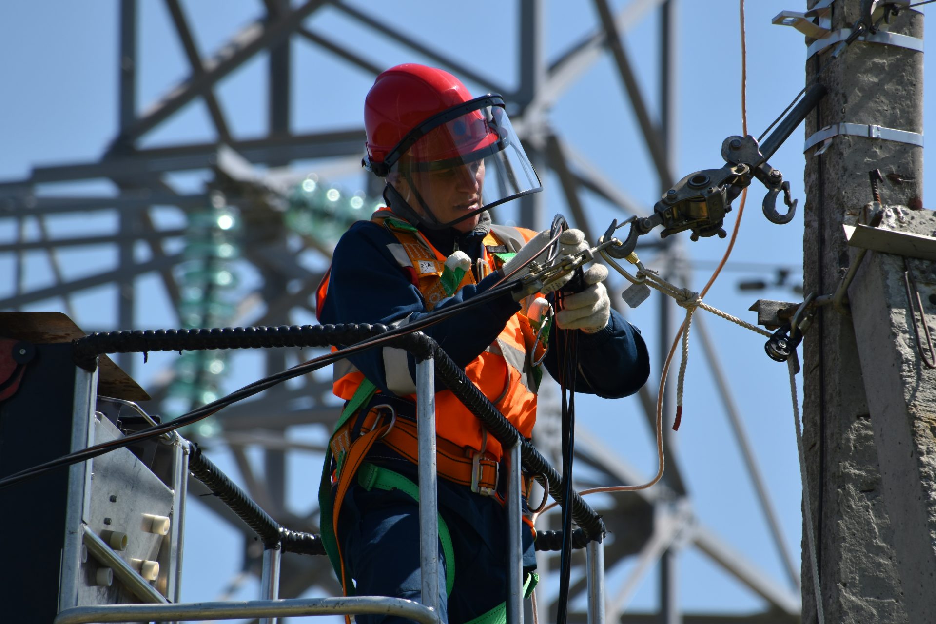 Fotografía con poca nitidez de un hombre arreglando un cable de acero.